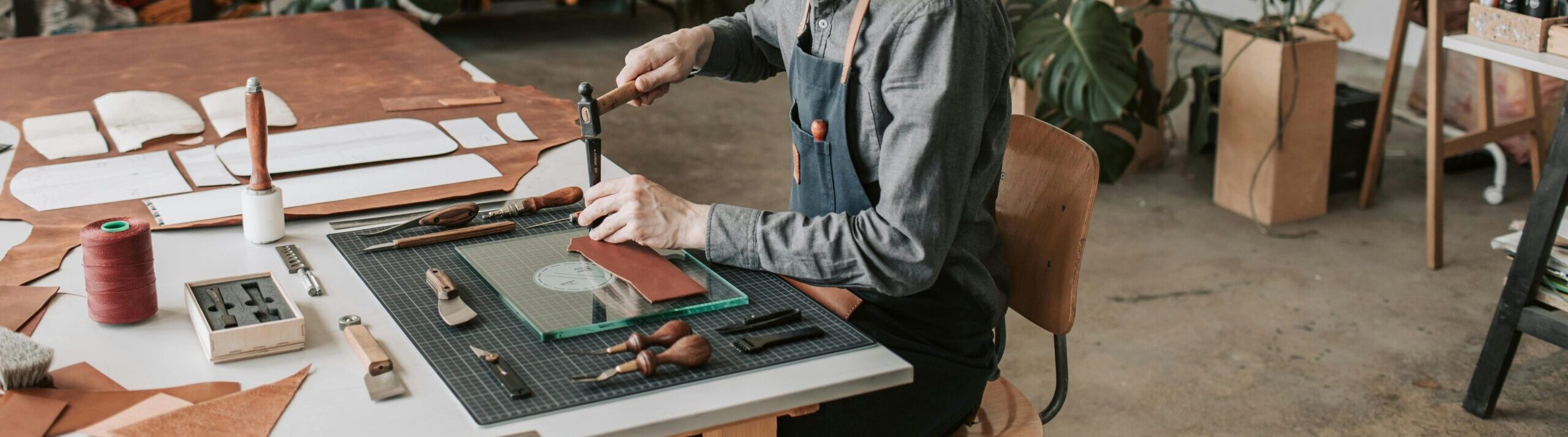 pexels-photo-4452633-4452633 Leather craftsperson working at a table in a stylish workshop.